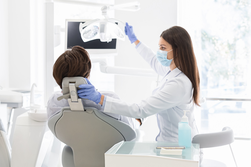 Female dentist with her patient sitting in chair
