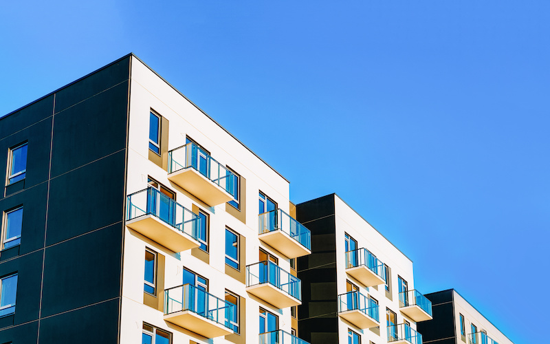 Modern residential apartment with flat buildings exterior, real estate property and condo architecture. Blue sky