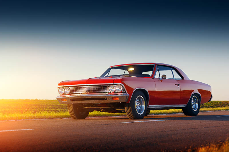 Retro red car stay on asphalt road at sunset Renters just moved into modern house, delivery service with boxes