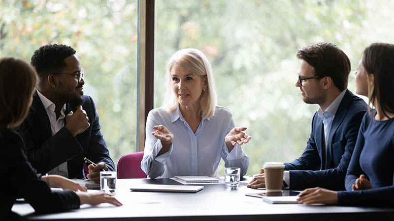 Mature leader boss give helpful information to young diverse professionals Boats docked at a small marina