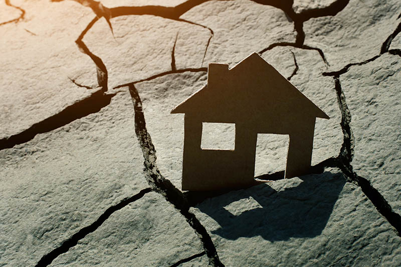 Paper house on cracked earth Renters just moved into modern house, delivery service with boxes