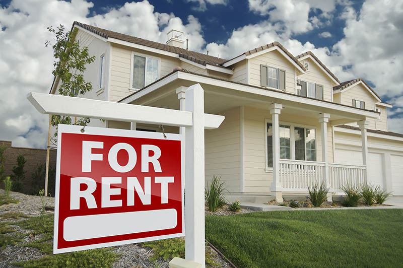 Right Facing Red For Rent Real Estate Sign in Front of Beautiful House. Renters just moved into modern house, delivery service with boxes